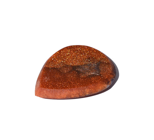 The right side of a polished, resin guitar pick with a rich amber-brown color and fine golden glitter