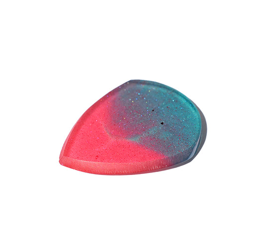 Right side angle of teal and pink resin guitar pick with cream bevel edge