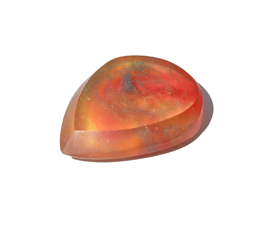 A polished, resin guitar pick with a swirling pattern of vibrant red, orange, and yellow. Right side view