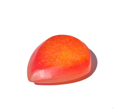 Right side angle of a translucent resin guitar pick with a gradient of orange and pink