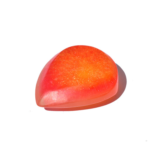 Right side angle of a translucent resin guitar pick with a gradient of orange and pink
