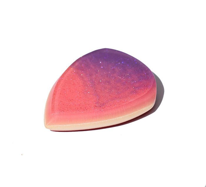 Right side angle of pink and purple glitter swirl resin guitar pick showing bevel profile