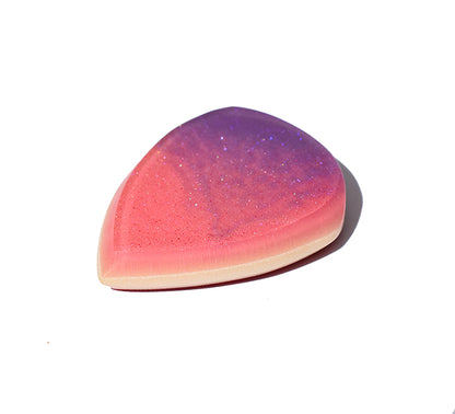 Right side angle of pink and purple glitter swirl resin guitar pick showing bevel profile