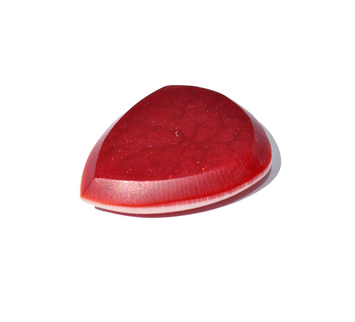 Right side angle of red glitter resin guitar pick with cream bevel edge